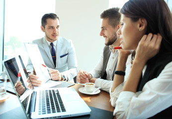 startup business team on meeting in modern bright office interior brainstorming, working on laptop and tablet computer.