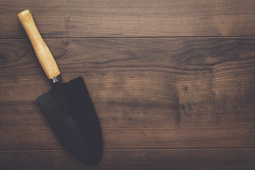 black gardening shovel on the wooden table with copy space