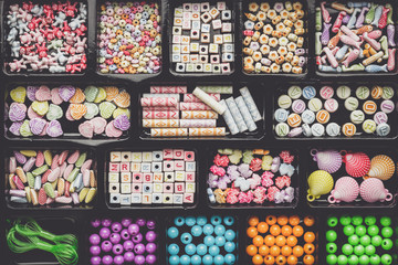 different colorful beads on the brown wooden table