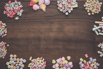 different colorful beads on the brown wooden table with copy space