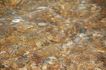 patterns in swirling sea water over pebbles