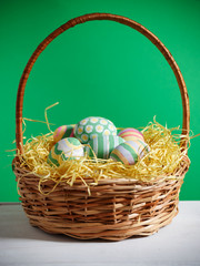 Basket with colorful Easter eggs, close up photo
