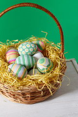 Basket with colorful Easter eggs, close up photo