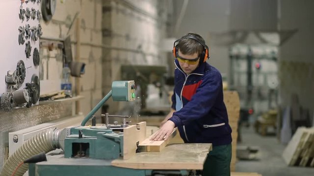 Craftsman cutting wooden plank with circular saw