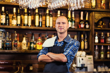Barman at work in pub,Portrait of cheerful barman worker standing,Waiter giving menus,A pub.Bar.Restaurant.Classic.Evening.European restaurant.European bar.American restaurant.American bar.