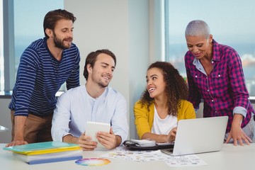 Team of graphic designers discussing over laptop