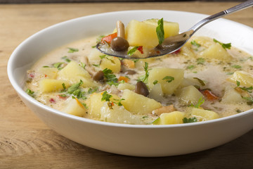Spoon with potatoes soup with mushrooms and sour cream