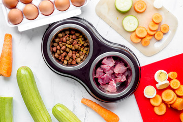 food for pets with meat and eggs on kitchen background top view