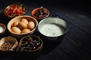 Components for chocolate cake on wooden table