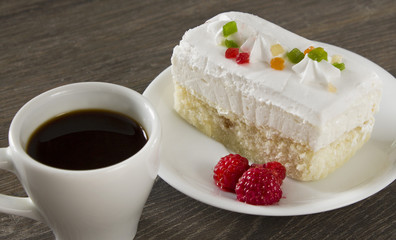 A cup of coffee with cake and raspberries