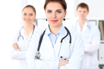 Fototapeta premium Happy female doctor with medical staff at the hospital. Successful team at health care concept