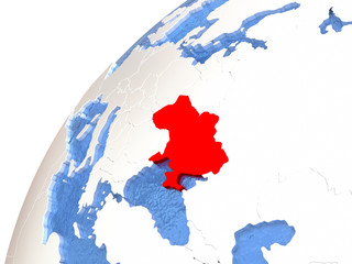 Ukraine on metallic globe with blue oceans