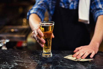 Bartender pouring the fresh beer in pub,barman hand at beer tap pouring a draught lager beer,beer from the tap,Filling glass with beer,fresh beer,pub.Bar.Restaurant.European bar.American bar.