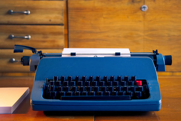 old blue retro typewriter in a antique wooden room, writing letter 