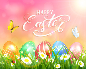 Happy Easter on pink background and eggs on grass