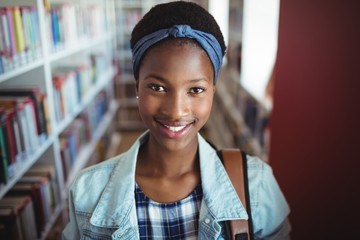 Portrait of schoolgirl smiling in library