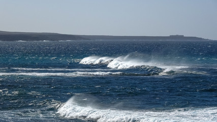 Ocean waves on the black rocky coastline in Canarias