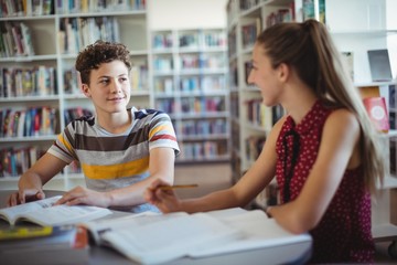 Classmates interacting while doing homework in library