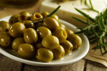 Fresh tasty greek green olives with cheese feta or goat cheese. Closeup. Mediterranean food.