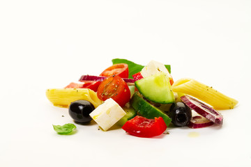 Tasty colorful appetizing ingredients for greek vegetable salad with pasta penne on bright background.