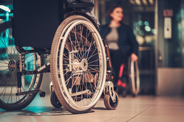 Disabled woman waiting for elevator in a store - obrazy, fototapety, plakaty