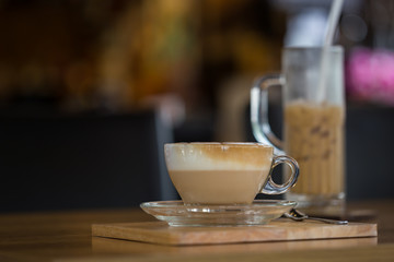 Hot beverage in a red cup placed on a modern cafe table with warm ambiance.