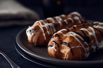 Sweet eclair dessert on black background