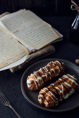 Sweet eclair dessert on black background