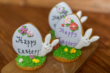 Colorful easter rabbits cookies on wooden background. Festive decoration. Happy Easter.