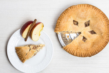 Apple pie cake lying on wooden white background on plate