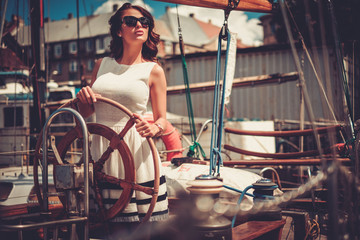 Fototapeta na wymiar Stylish wealthy woman on a luxury wooden regatta