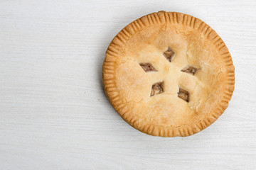 Apple pie cake lying on wooden white background