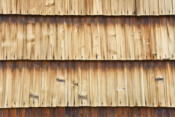 Wall of the building shingle with boards.
Wooden lining of a building wall with stains.