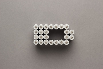 conceptual image of battery charge level pictogram made of rechargeable batteries over gray...
