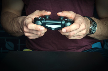 Man holding game controller sitting on ble sofa © Adga