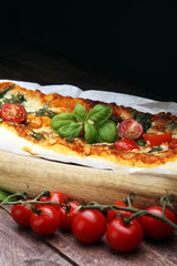 Hot pizza slice with melting cheese on a rustic wooden table.