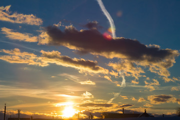 Beautiful sunset or sunrise with colourful clouds and the plane trace.