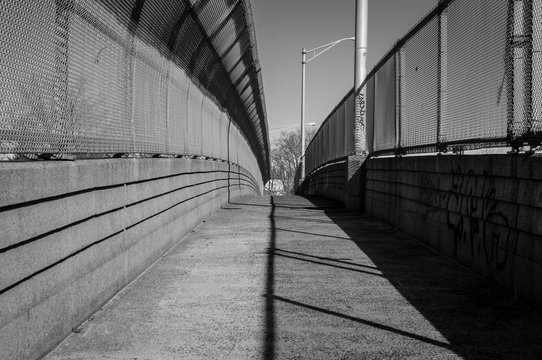 Fototapeta Urban chain link fence walkway. Industrial art and design. Overpass concrete bridge walkway.Black and white. Abstract art and design. Outdoor architectural detail and design. Abstract colors. 