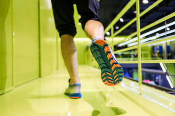 Close up runner feet. Man runner legs and shoes in action at sport shop.