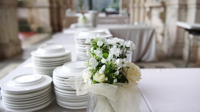 Wedding dinner preparation, beautiful flowers and white plates, selective focus, 4K