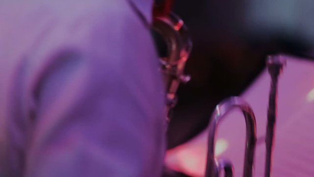Musicians with trumpet, guitar and sax of band are playing music at musical bar