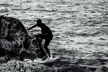 man climbing rock in summertime