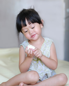 Little child girl eating boiled eggs at home.