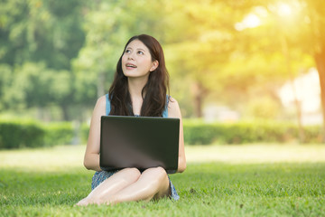 beautiful asian woman using computer in outdoor park