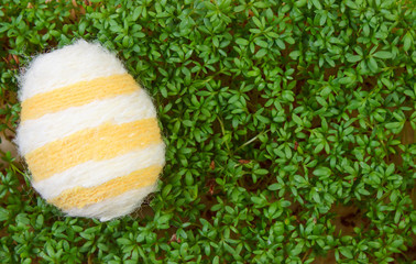 Easter eggs wrapped woolen string and green cress, copy space for text, decoration for Easter