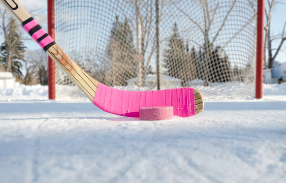 Pink hockey stick outdoor rink on a blue sky day close-up
