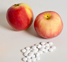 Ripe apples and white pills