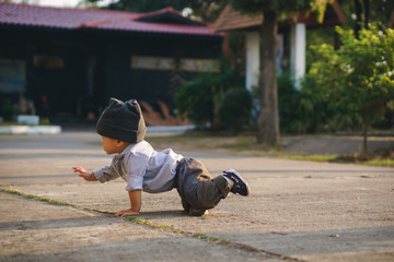Asian boy learning to walk and fall