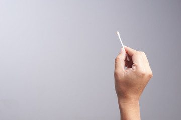 Hand holding dirty cotton bud or swab with ear wax