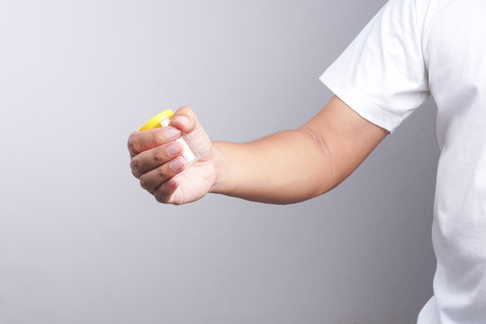 Hand holding empty urine plastic container
